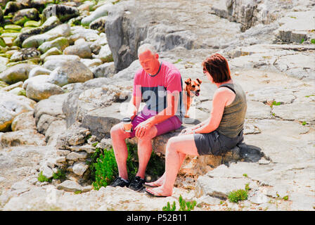 Dorset, UK. 24th June 2018. People get close to the sea, sitting on the rocks at the water's edge:  Portland Bill,  Dorset Credit: stuart fretwell/Alamy Live News Stock Photo