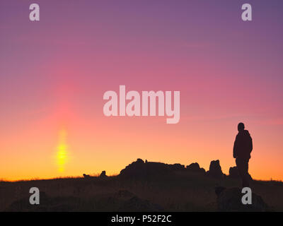 Brassington, Derbyshire, UK. 24th June, 2018. Weather UK: person watching the sun pillar solar column during an amazing sunset at Harborough Rocks near Brassington & the High Peak Trail, Derbyshire, Peak District National Park Credit: Doug Blane/Alamy Live News
