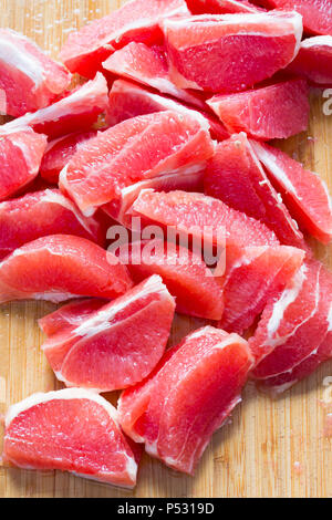 Red grapefruit pieces on wooden board Stock Photo