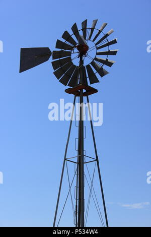 Summer fun windmill standing against the clear blue sky. Stock Photo