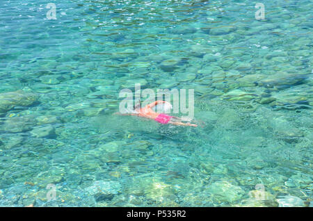 A man swimming near Sveti Nikola Island (known as 'Hawaii' or 'Školj'), Budva, Montenegro, Adriatic Coast, Balkans, May 2018 Stock Photo