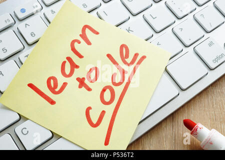 Learn to code written on a memo stick and keyboard. Stock Photo