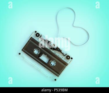 Translucent audio cassette with the magnetic tape in the shape of a heart  isolated on blue background, music love concept Stock Photo