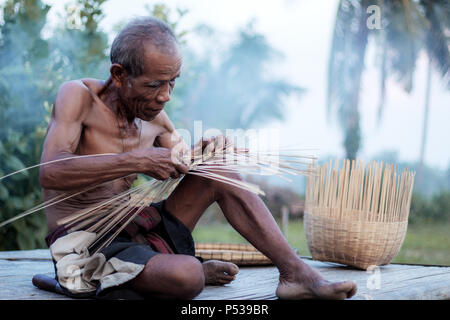 Old man of thailand are weaving bamboo basket. Stock Photo