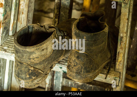 Old and dirty boots on a ladder. Stock Photo