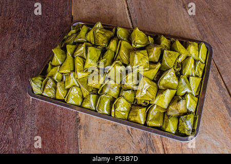 Stuffed Dough Pyramid Dessert put on tray on brown wooden background for Chinese New Year festival. Kanom Tian. Stock Photo