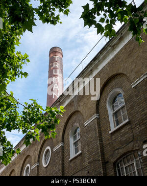 The Old Truman Brewery building on Brick Lane, East London UK, with iconic chimney, now used as a retail, leisure and business event space. Stock Photo