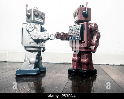 two vintage robot shake hands on a old wooden floor  toned image Stock Photo