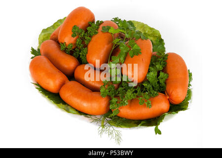 Sausages with green tomatoes and a slice of bread on a plate. Isolated white background. Stock Photo