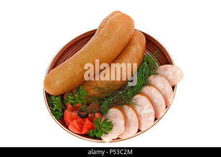 Sausages with green tomatoes and a slice of bread on a plate. Isolated white background. Stock Photo