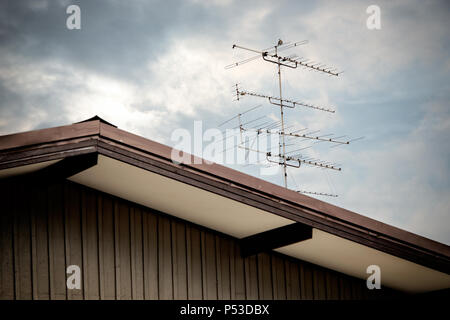 Close up Classic old TV antenna on house roof over cloudy sky Stock Photo