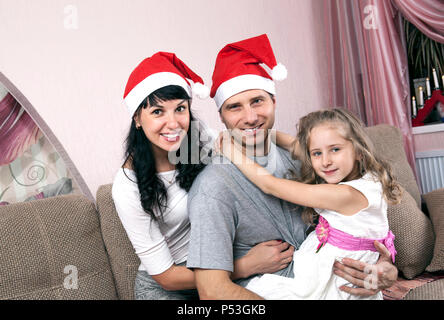 young family of three in Christmas hats Stock Photo