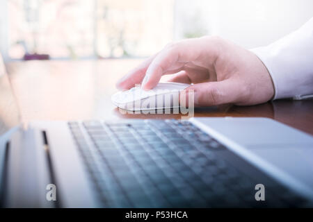 Businessman Working With Mouse And Computer On A Table In Front Of A Bright Window Stock Photo