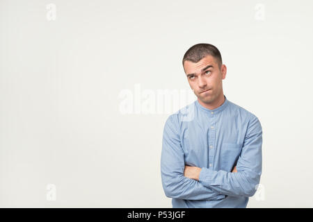 Let me think or oubt concept. Young hispanic man is very serious and pensive, trying to solve problems in job Stock Photo