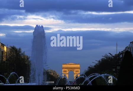 France. Paris. Night view of the Champs Elysees with the Triumphal Arch in the background. Stock Photo