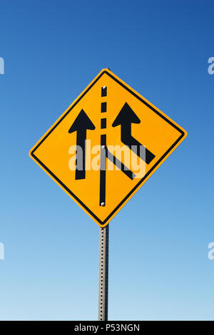 Traffic merge sign and blue sky. Stock Photo