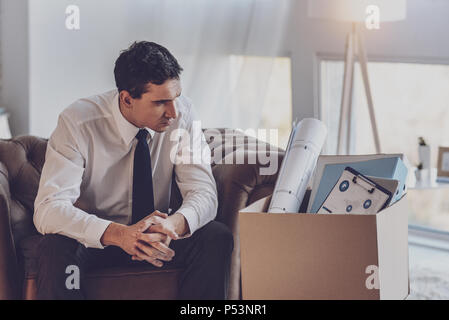 Depressed unhappy man looking at his box Stock Photo