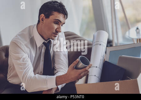 Depressed nice man looking at the cup Stock Photo