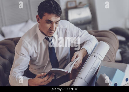 Depressed young man looking at his planner Stock Photo