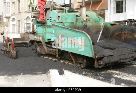 Paving work. Asphalt paving machine. New asphalt surface on the carriageway. Barcelona. Spain. Stock Photo