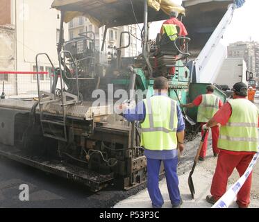 Paving work. Asphalt paving machine. New asphalt surface on the carriageway. Barcelona. Spain. Stock Photo