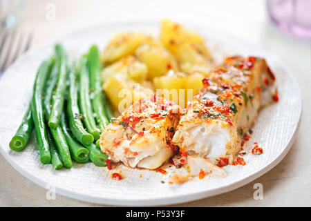 Tomato & basil chargrilled cod with green beans and potatoes Stock Photo