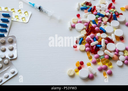 Blisters and colorful pills on a white background. Stock Photo