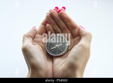 Girl in the palms holds a compass on a white background Stock Photo