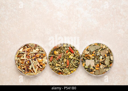 a set of three Chinese herb teas in round bowls against ceramic background with a copy Stock Photo