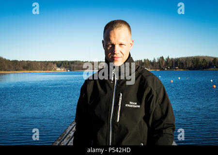 Portrait of male caucasian middle age boxer man outside in nature at lake in Sweden. Nice sunny winter day with blue sky. Wearing black sport jacket. Stock Photo