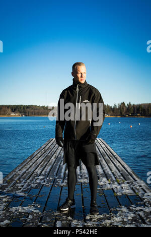 Portrait of male caucasian middle age boxer man outside in nature at lake in Sweden. Nice sunny winter day with blue sky. Wearing black sport jacket. Stock Photo