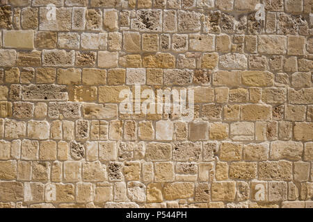 Sandstone, limestone aged wall at Cyprus. Yellow stonewall backdrop, close up view with details. Stock Photo