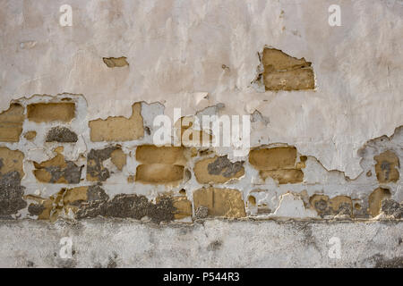 Sandstone, aged stonewall at Cyprus. Pink peeled plaster on yellow limestone wall background, close up view with details. Stock Photo