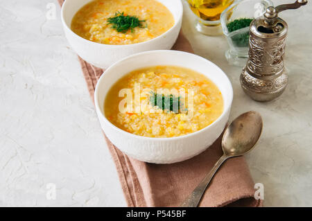 Lentil and bulgur soup puree in a white bowl on a white stone ba Stock Photo