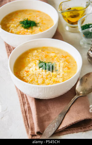 Lentil and bulgur soup puree in a white bowl on a white stone ba Stock Photo