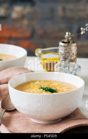 Lentil and bulgur soup puree in a white bowl on a white stone ba Stock Photo