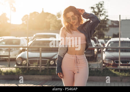 Portrait of Young and Beautiful Woman in Casual Clothes in the Street. Dressed in Pink Shirt and Pants. Spring, Summer Concept. Relax Time. Girl with  Stock Photo