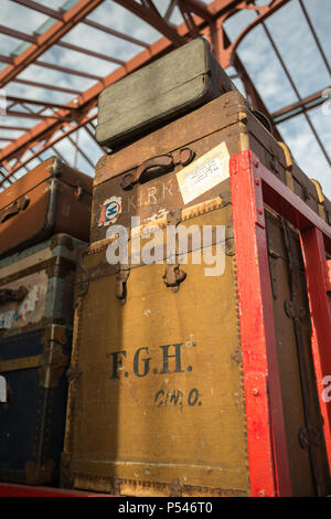 Low angle close up, vintage luggage stacked on railway trolley at vintage UK train station on Severn Valley Railway heritage line for 1940s WWII event. Stock Photo