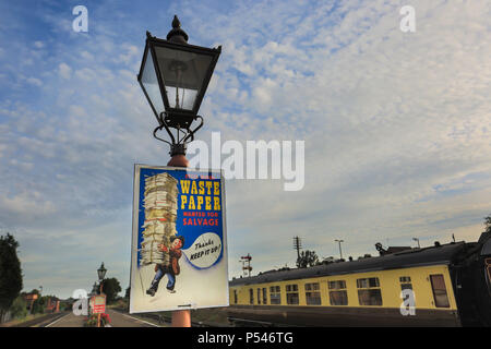 1940's community spirit WWII wartime poster on lamp post of vintage gas lantern, empty heritage railway station, UK: Waste Paper wanted for Salvage. Stock Photo