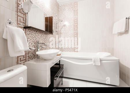 Bathroom Inside rooms of a apartment or hotel. Clean white towel and bathrobe on a hanger prepared to use. Stock Photo