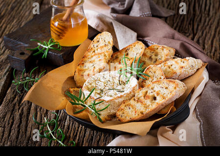 Baked cheese Camembert with rosemary and honey. Tasty food. Stock Photo
