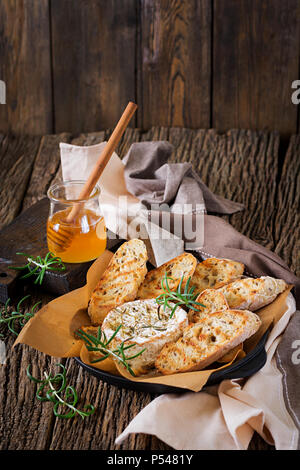 Baked cheese Camembert with rosemary and honey. Tasty food. Stock Photo