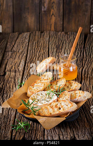 Baked cheese Camembert with rosemary and honey. Tasty food. Stock Photo