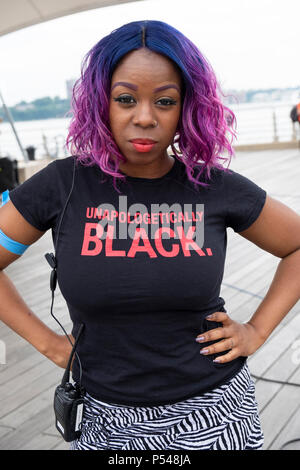 Posed portrait of a security guard at a rally wearing a tee shirt that says UNAPOLOGETICALLY BLACK. In Greenwich Village in New York City. Stock Photo