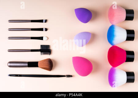 Cosmetics accessories for makeup on beige background flat lay. Set of cosmetics brushes. Minimal composition. Fashion and beauty blogging concept. Top Stock Photo