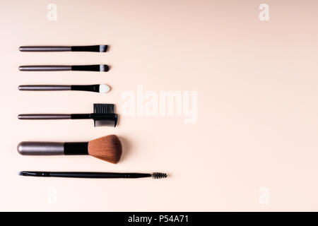 Cosmetics accessories for makeup on beige background flat lay. Set of cosmetics brushes. Minimal composition. Fashion and beauty blogging concept. Top Stock Photo