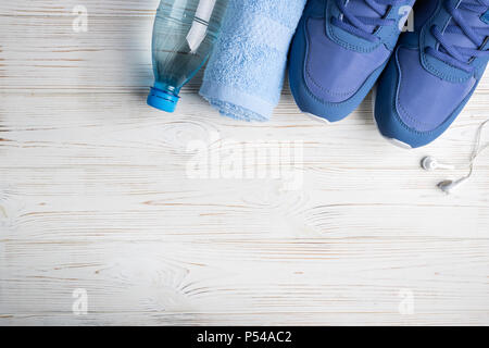 Flat lay sport shoes, bottle of water, towel and earphones on white background. Sport equipment. Healthy lifestyle, sport and diet concept. Copy space Stock Photo