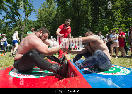 KAZAN, RUSSIA - JUNE 23, 2018: Traditional Tatar festival Sabantuy - Strong muscular men in battle of pulling the stick outdoors Stock Photo