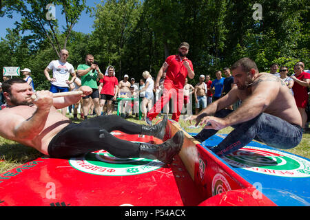 KAZAN, RUSSIA - JUNE 23, 2018: Traditional Tatar festival Sabantuy - Adult strong men wrestling at pulling the stick outdoors Stock Photo