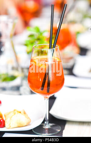 A orange drink in a glass of wine in the restaurant beautifully served. Stock Photo
